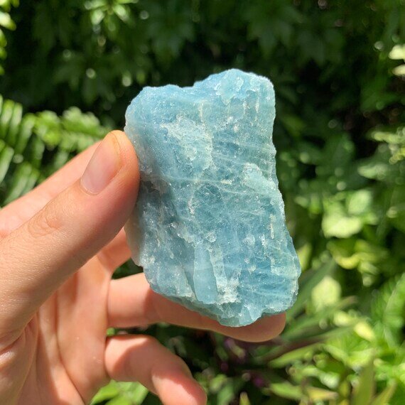 Grade aa aquamarine raw held in hand for size reference