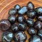 Detail shot of Grade AA Garnet tumbled stone under natural light