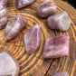 Detail shot of Grade AAA Blue Rose Quartz tumbled stone under natural light