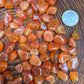 Back view of Grade AA Carnelian tumbled stone showing natural surface