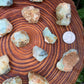Soft-light view of Prehnite raw crystal, set against a soft neutral surface.