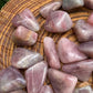 Detail shot of Grade AAA Blue Rose Quartz tumbled stone under natural light