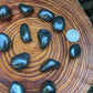 Detail shot of Grade AA Hematite tumbled stone under natural light