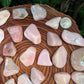 Side-on view of Pink Opal tumbled stone, showing color depth, sourced from Peru.