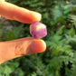 Detail shot of Grade AA Chevron Amethyst tumbled stone under natural light