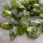 Wider context of Peridot tumbled stone, captured in natural daylight.