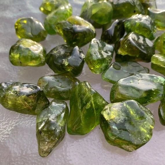 Wider context of Peridot tumbled stone, captured in natural daylight.