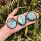Close-up of gray Labradorite palm stone, sourced from Atsimo-Andrefana, Madagascar, showing natural variation.