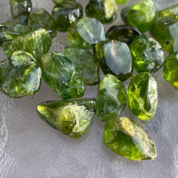 Daylight view of a Peridot tumbled stone, from San Carlos Apache Reservation, Arizona, United States.