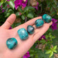 Back view of Grade AA Chrysocolla tumbled stone showing natural surface