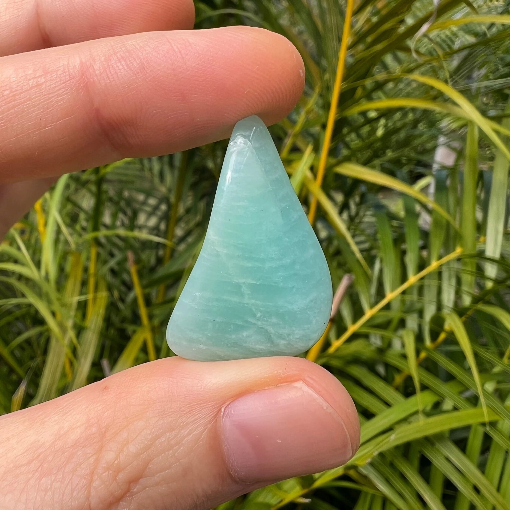 Detail shot of Grade AA Amazonite tumbled stone under natural light