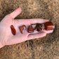Detail shot of Grade AA Red Jasper tumbled stone under natural light
