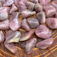 Worktop view of Blue Rose Quartz tumbled stone, from Alaotra-Mangoro, Madagascar, in the warmth of daylight.