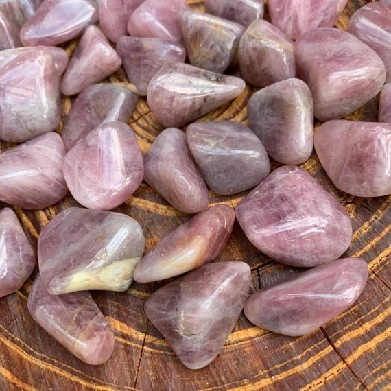 Worktop view of Blue Rose Quartz tumbled stone, from Alaotra-Mangoro, Madagascar, in the warmth of daylight.