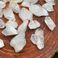 Wider context of Clear Quartz raw crystal, from Arkansas, United States, shown alongside the hand for scale.