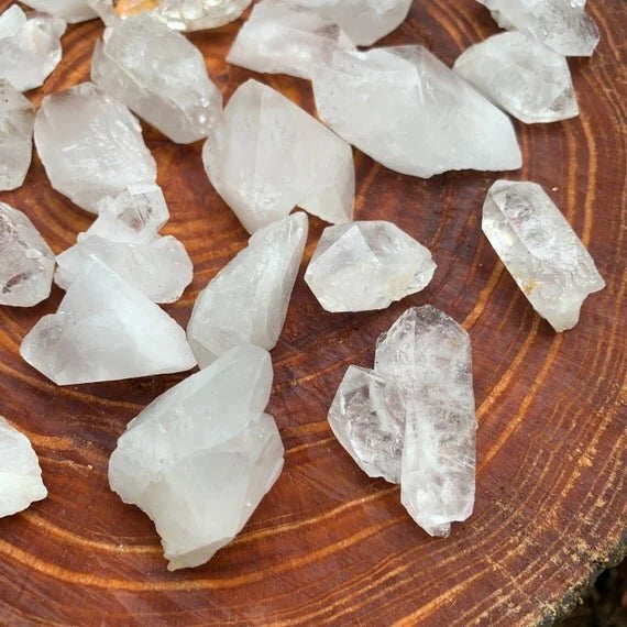 Wider context of Clear Quartz raw crystal, from Arkansas, United States, shown alongside the hand for scale.