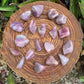 Opposite side of Blue Rose Quartz tumbled stone, showing matte finish.