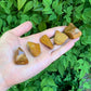 In-hand view of a Yellow Jasper tumbled stone, from Madagascar.