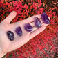 Whole-piece view of Amethyst tumbled stone, with natural details visible.