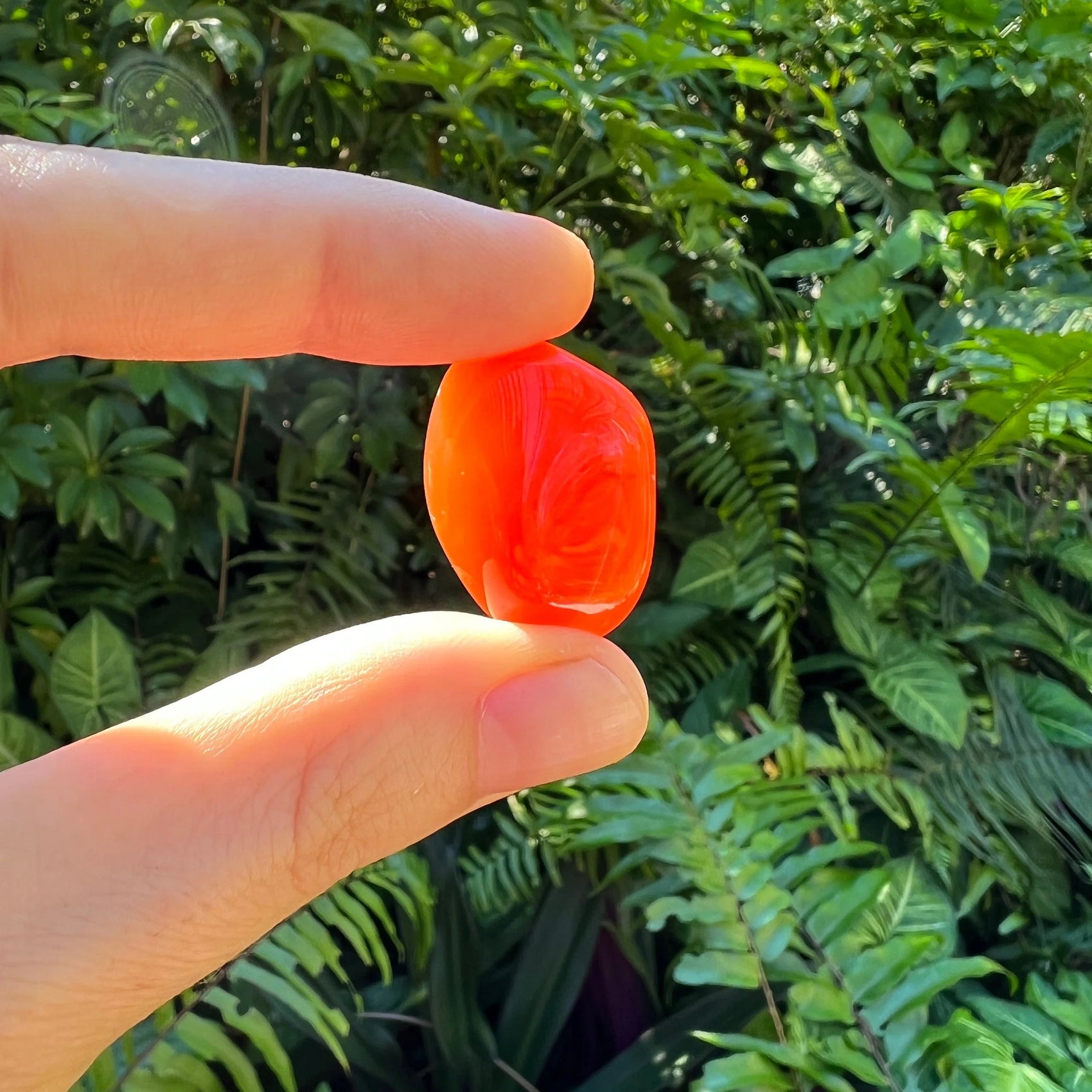 Lifestyle view of a single Carnelian tumbled stone sourced from Francistown, Botswana.