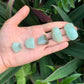 Back view of a Grade AA Prehnite tumbled stone showing pale green natural surface, Erongo, Namibia