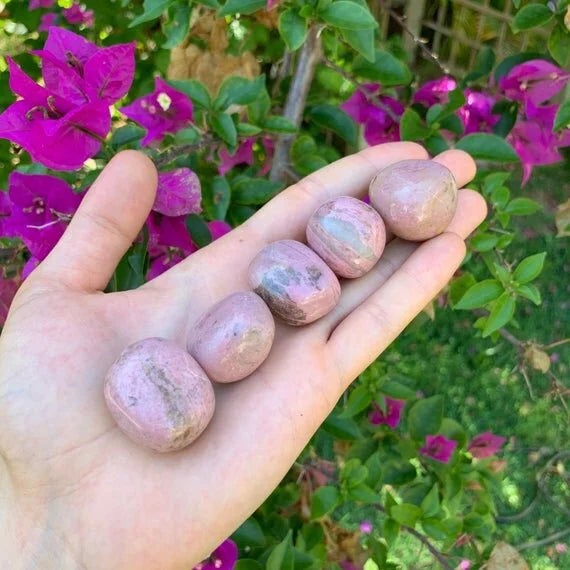 Detail shot of Grade AA Rhodonite tumbled stone under natural light