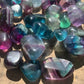 Back view of Grade AAA Fluorite tumbled stone showing natural surface