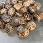 Detail shot of Grade AA Brown Aragonite tumbled stone under natural light