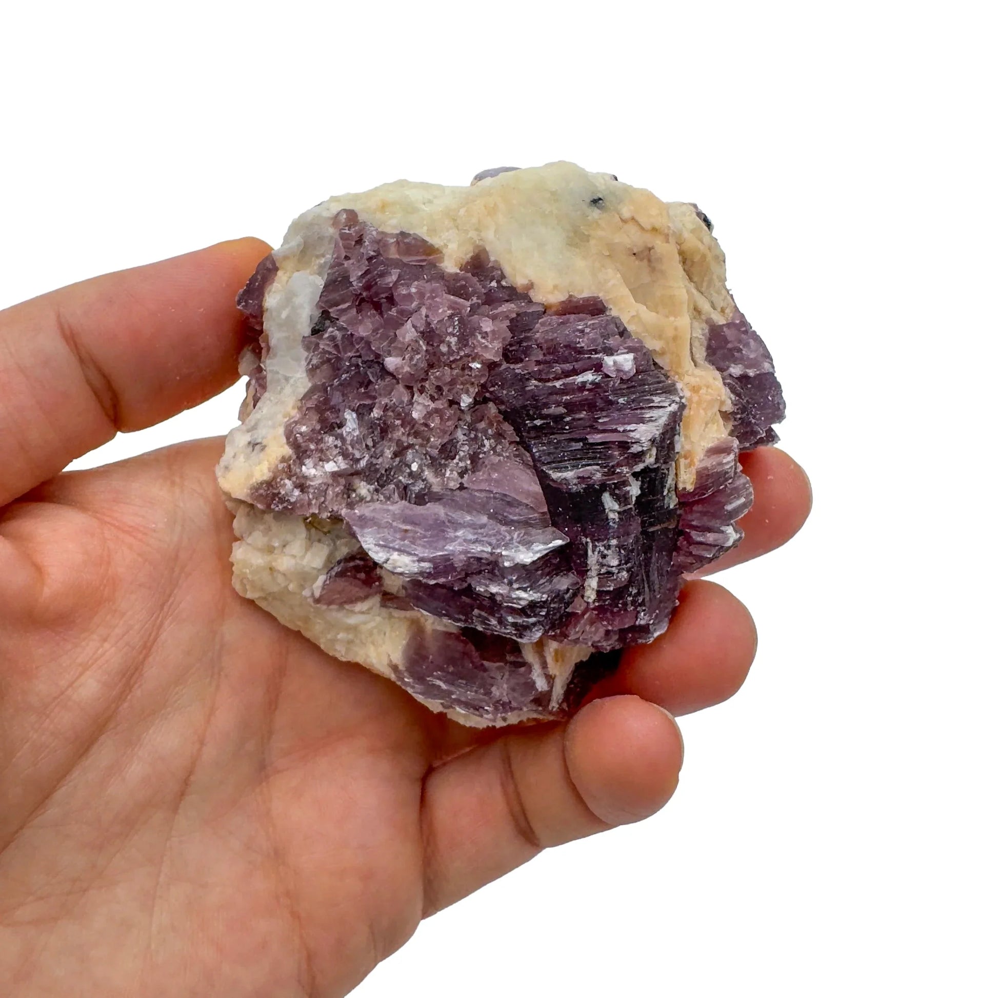 Held against neutral backdrop is a Lepidolite specimen, linked to Self Love, showing the wear and finish.