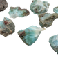 Several Larimar rough pieces showing the range of blue saturation across the batch