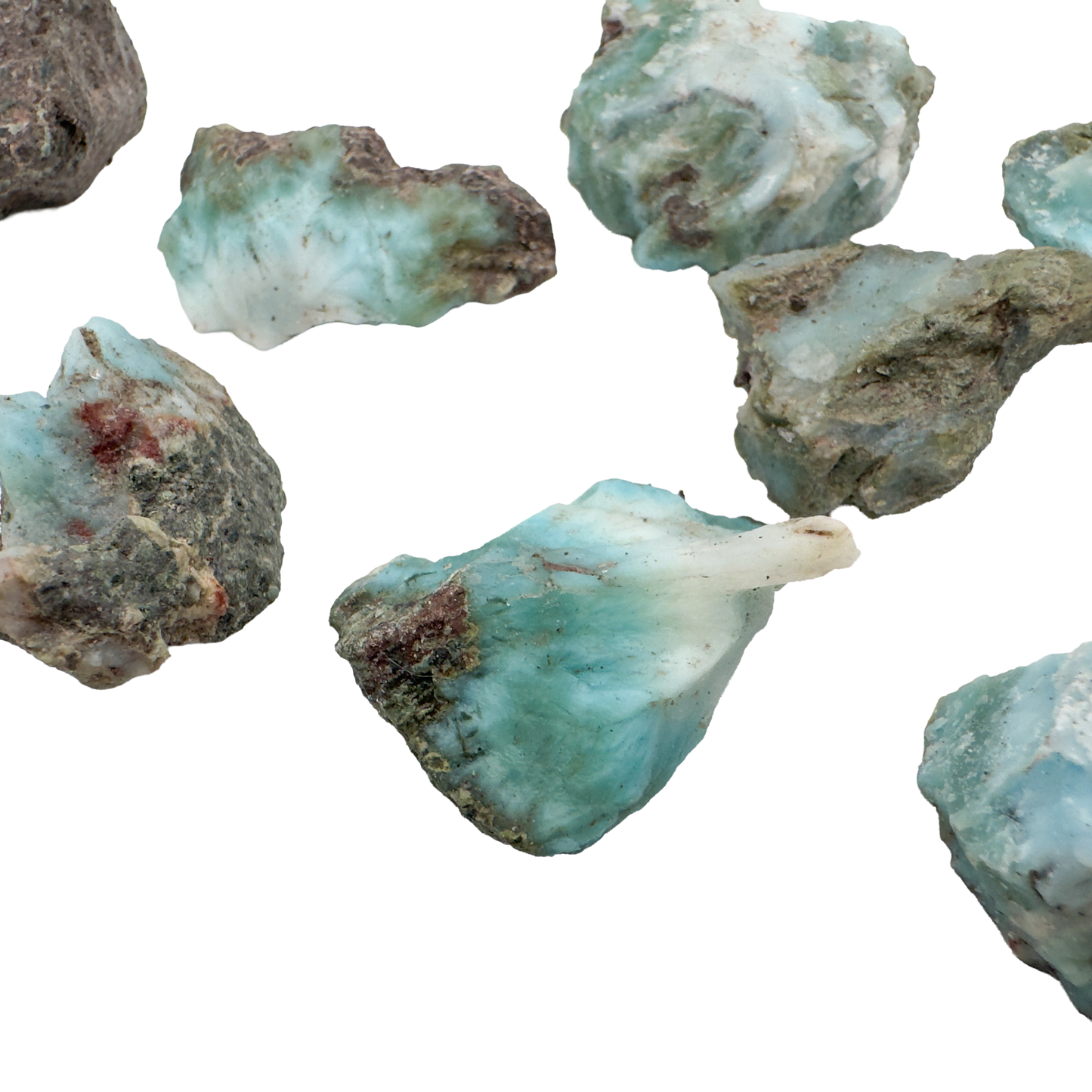 Several Larimar rough pieces showing the range of blue saturation across the batch