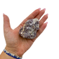 Lepidolite crystal specimen from Brazil held in hand to show scale