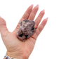 Lepidolite crystal specimen from Brazil held in hand to show scale