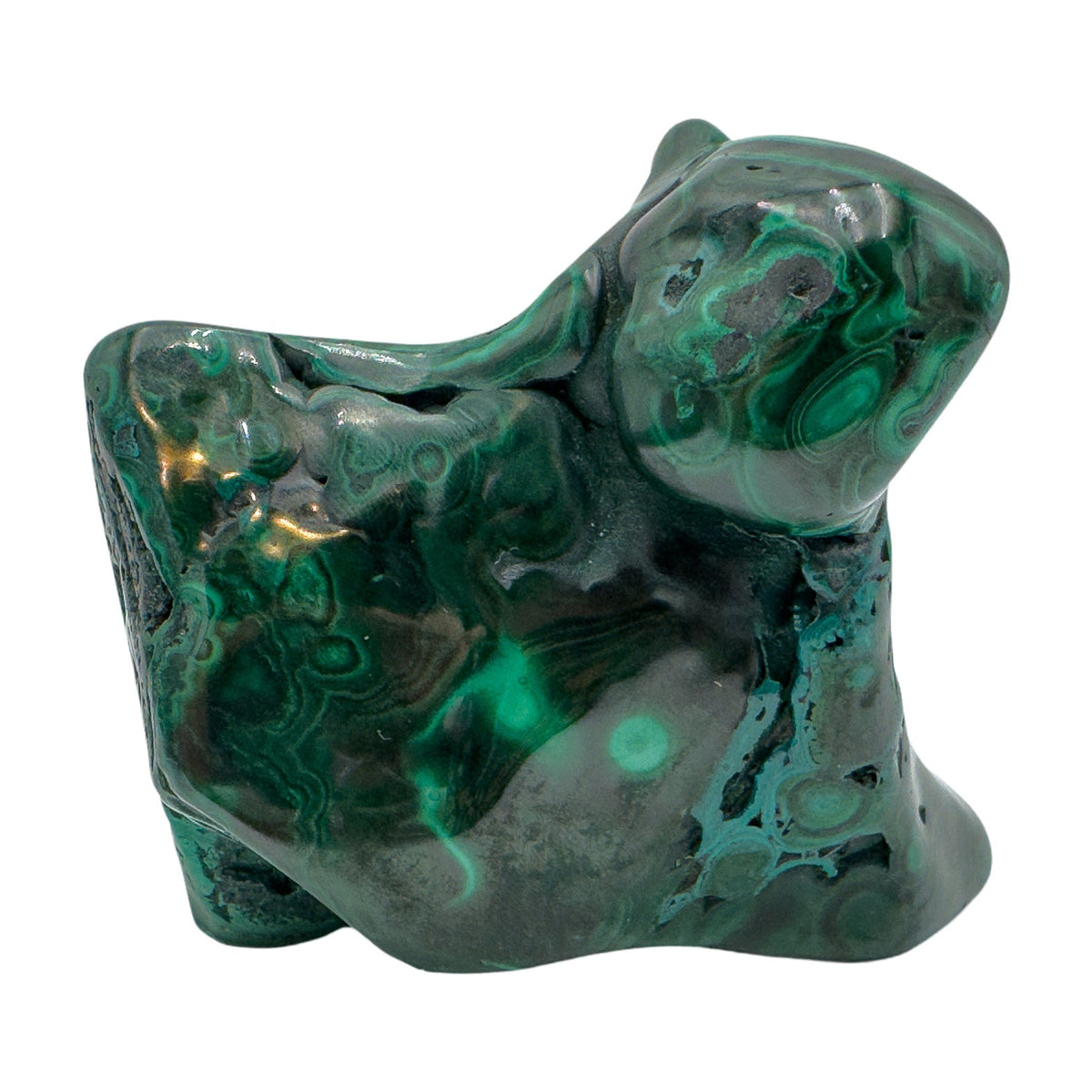 Angled view of the malachite specimen with a pointed lobe and softer light across the banded surface.