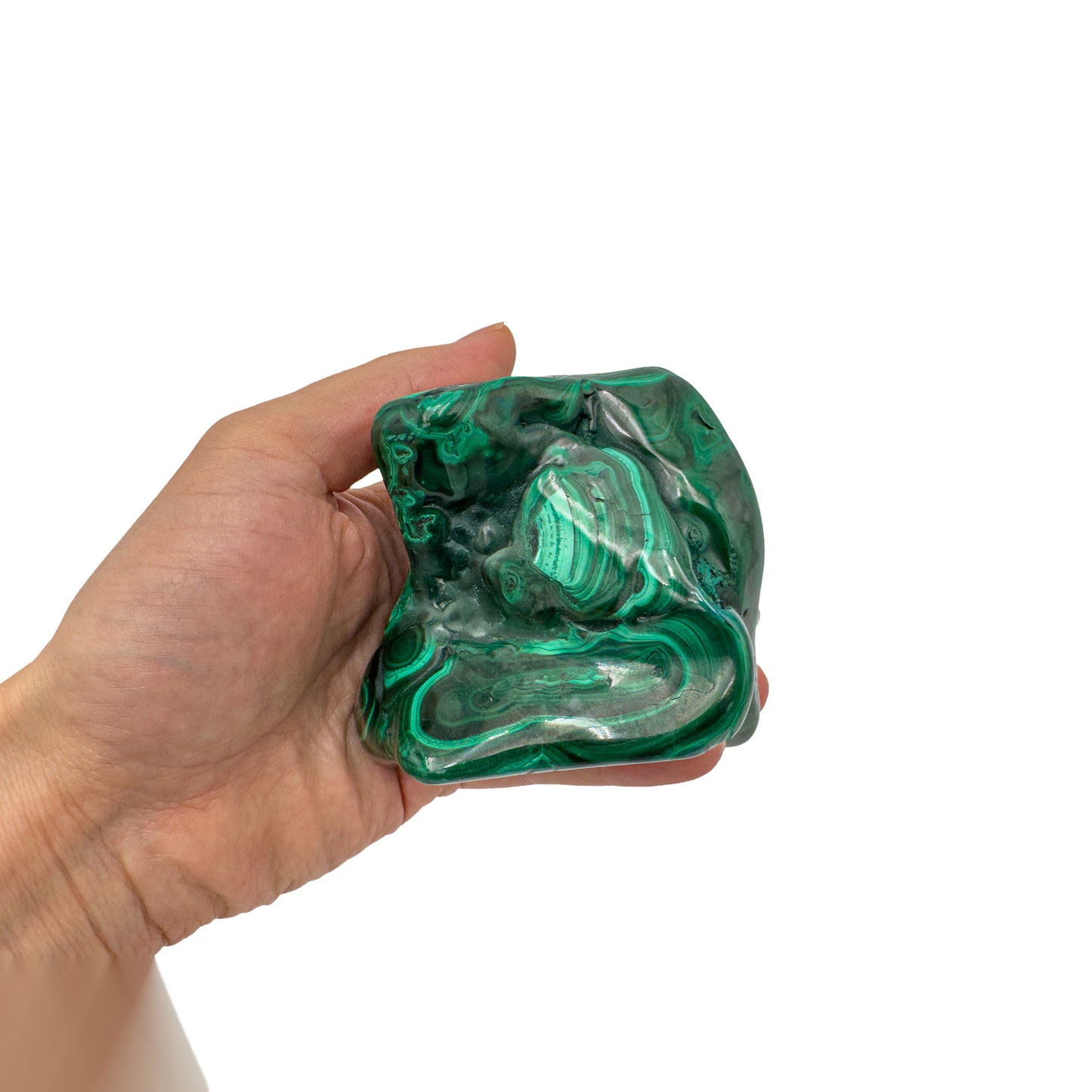 Malachite specimen held in hand for scale, showing its rounded, all-around polished form measures roughly 3.5 inches across.