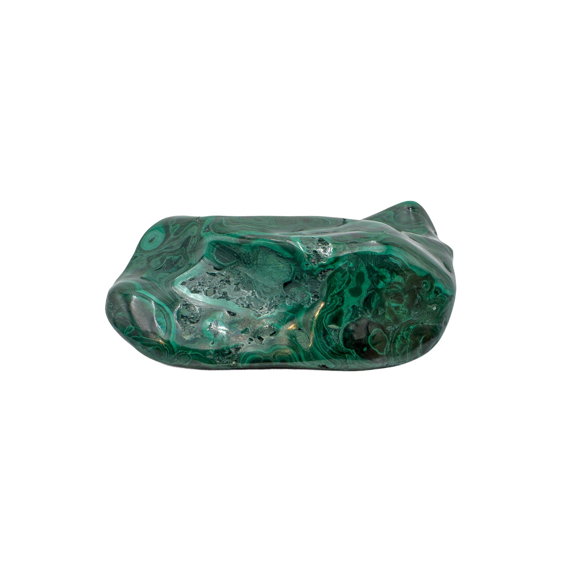 Malachite specimen viewed from a compact angle, its banded top face catching the light across a low, wide stone.
