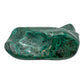 Malachite specimen viewed from a compact angle, its banded top face catching the light across a low, wide stone.