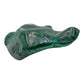 Close side profile of the malachite specimen, showing the jagged natural edge where the polish meets the raw stone.