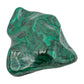 The same malachite specimen tilted upright, showing the pointed ridge along one edge of the polished face.