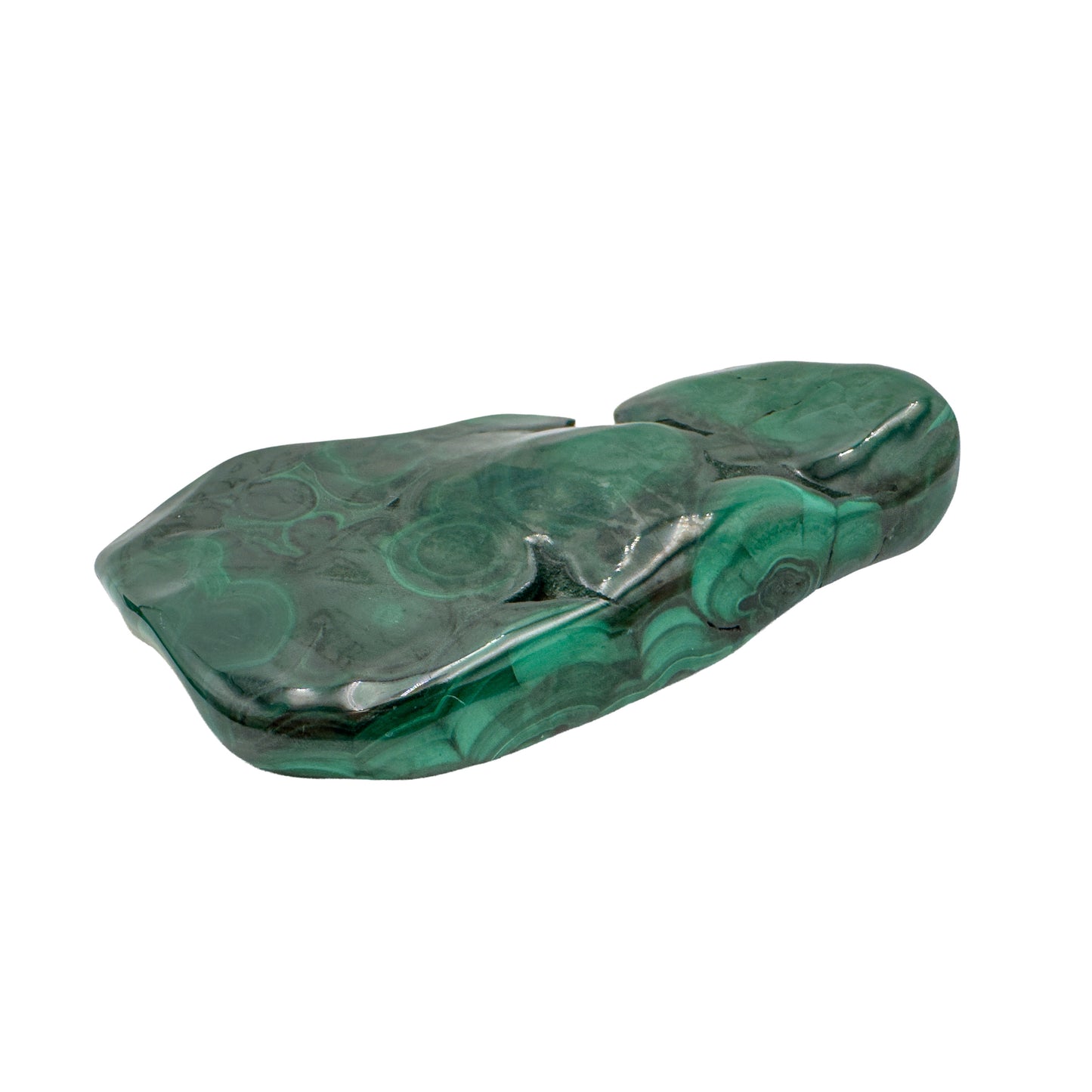 Flat lay of the malachite specimen showing stripes and partial bullseyes running end to end across its long polished face.