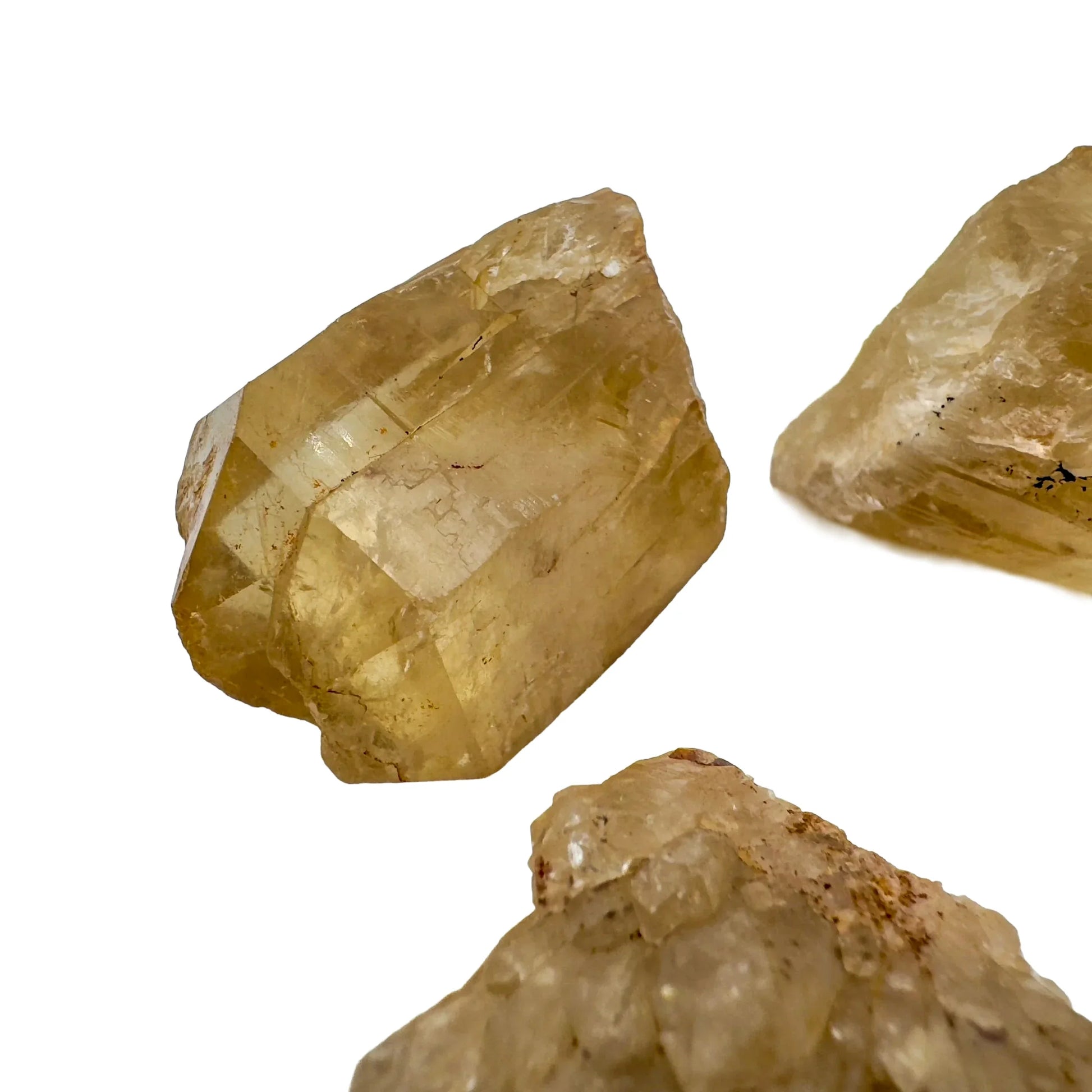 In-hand view of a Natural Citrine raw stone held against natural backdrop, from Democratic Republic of the Congo.