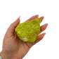 A hand holds nontronite no. 21 for scale, the 106 gram specimen spanning roughly 2.26 inches across the palm.