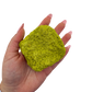 A hand holds nontronite no. 26 for scale, the 114 gram specimen spanning roughly 2.84 inches across the palm.