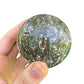 Held in hand is an Ocean Jasper stone, in the warmth of daylight.