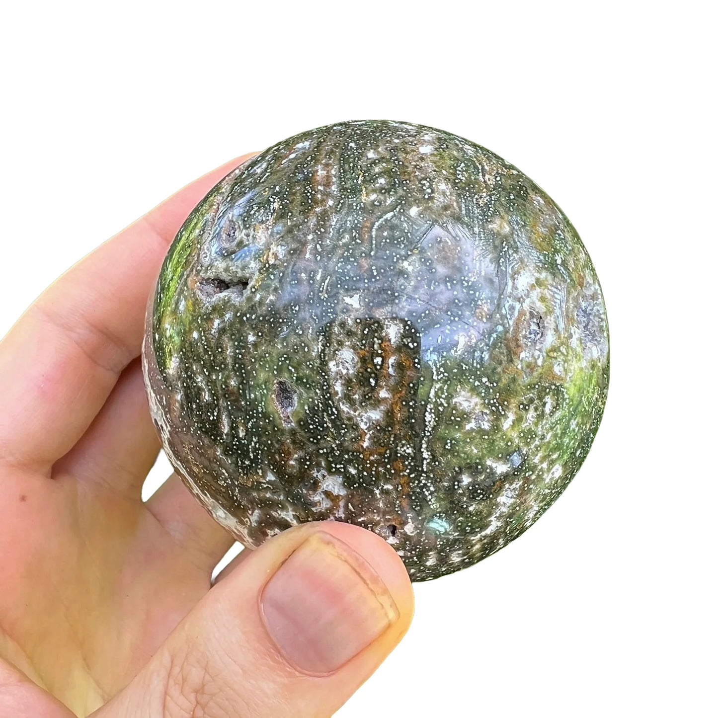 Held in hand is an Ocean Jasper stone, in the warmth of daylight.