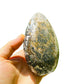 Held in palm of an Ocean Jasper stone, traditionally used for Emotional Healing, with natural details visible.