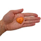 AA Grade Orange Calcite polished heart held in hand for scale, from Madagascar