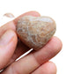 Detail shot of Grade AA Peach Moonstone heart under natural light