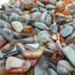 Pink agate crystal chips scattered on surface, ethically sourced Botswana chalcedony