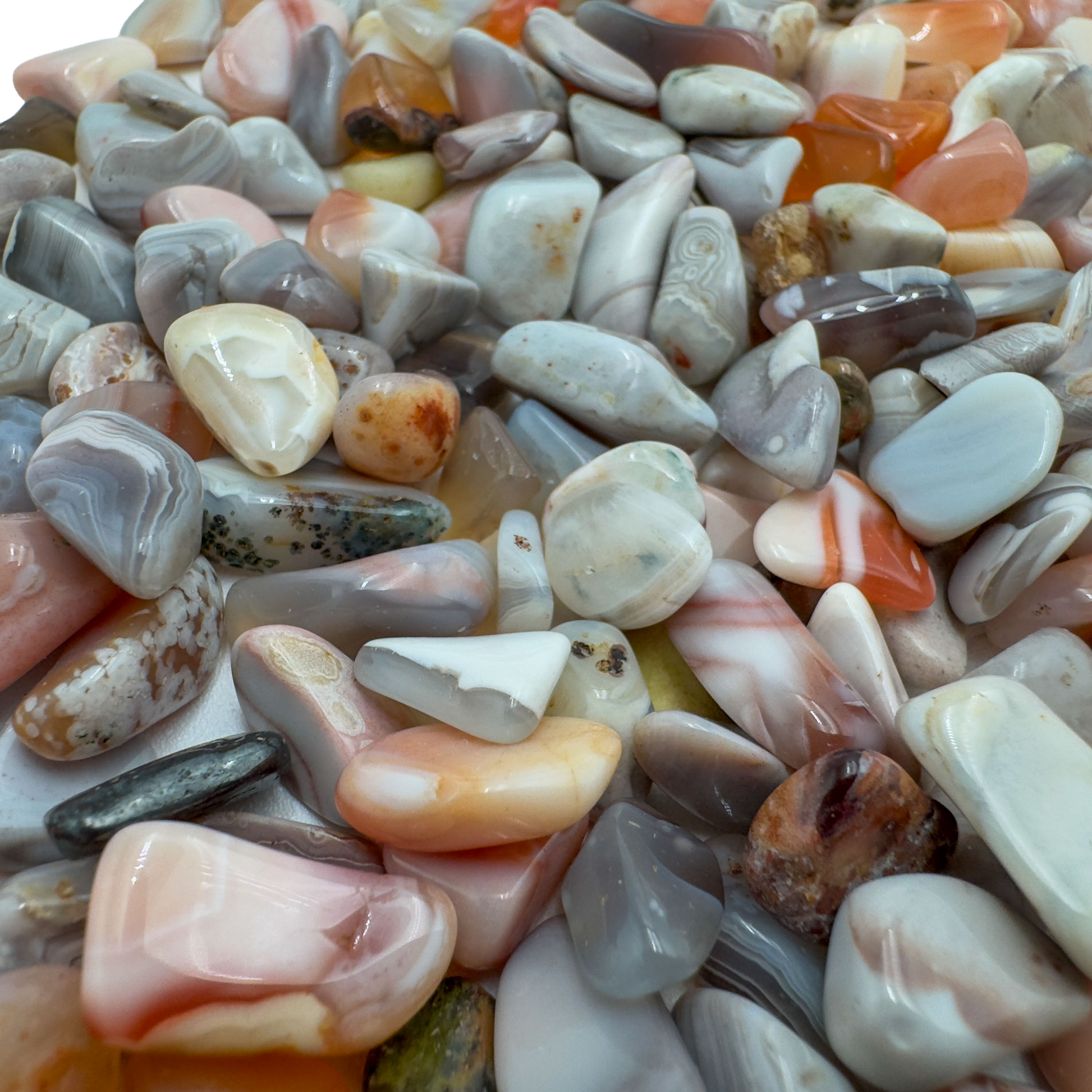 Pink agate crystal chips scattered on surface, ethically sourced Botswana chalcedony